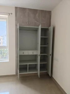 Budget laminate wardrobe interior with hanging rod, drawers and shelves in a Chennai 2 BHK flat